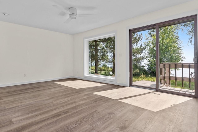 unfurnished room featuring wood finished floors, baseboards, and ceiling fan