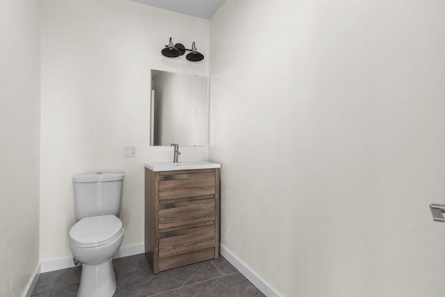 half bath featuring tile patterned floors, baseboards, toilet, and vanity