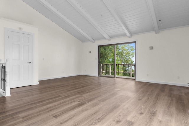 empty room with lofted ceiling with beams, baseboards, and wood finished floors