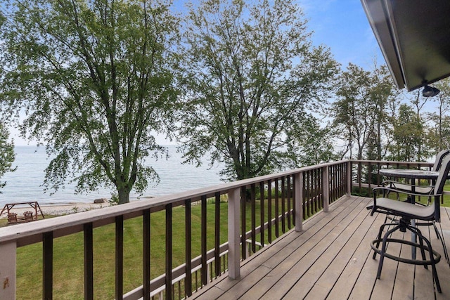 deck with a yard and a water view