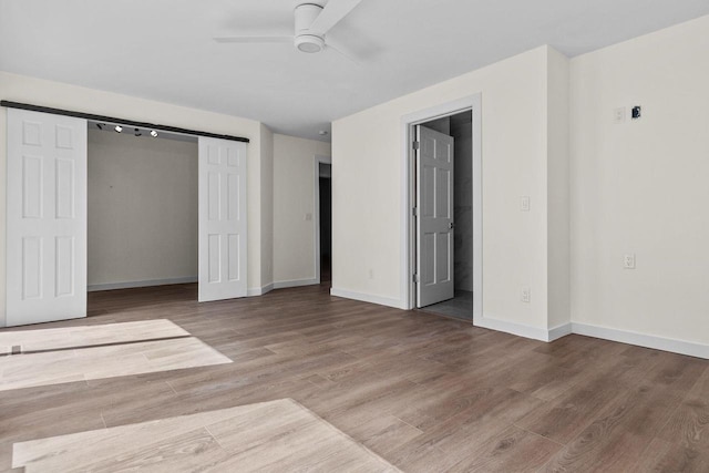 unfurnished bedroom featuring ceiling fan, a closet, baseboards, and wood finished floors