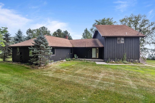 view of front facade featuring a chimney, board and batten siding, and a front yard