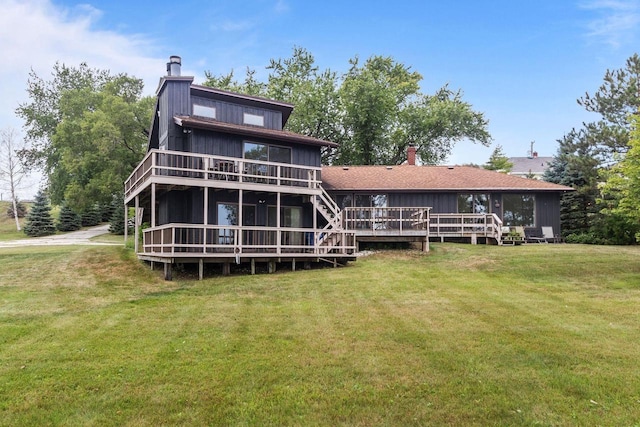 back of house featuring stairs, a yard, a deck, and a chimney