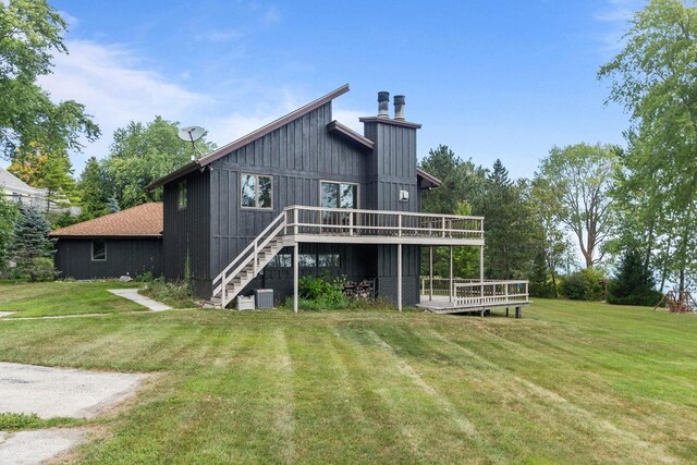 rear view of house with stairway, central AC unit, a wooden deck, and a yard