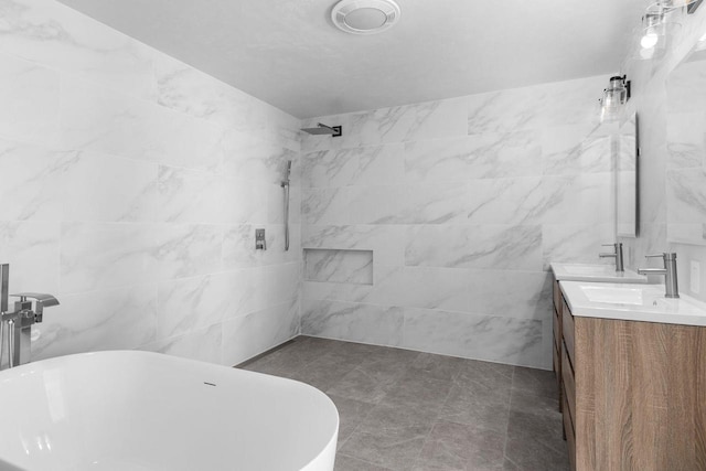 bathroom with a sink, tile walls, double vanity, tiled shower, and a freestanding bath