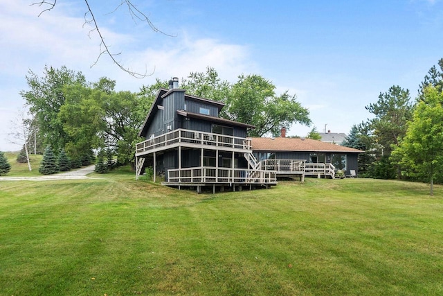 back of house featuring a deck, a chimney, and a yard