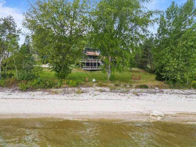 back of property with a yard and a water view