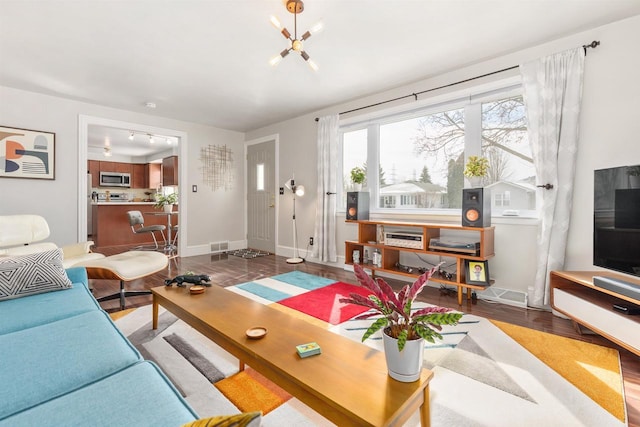 living room with visible vents, baseboards, and wood finished floors