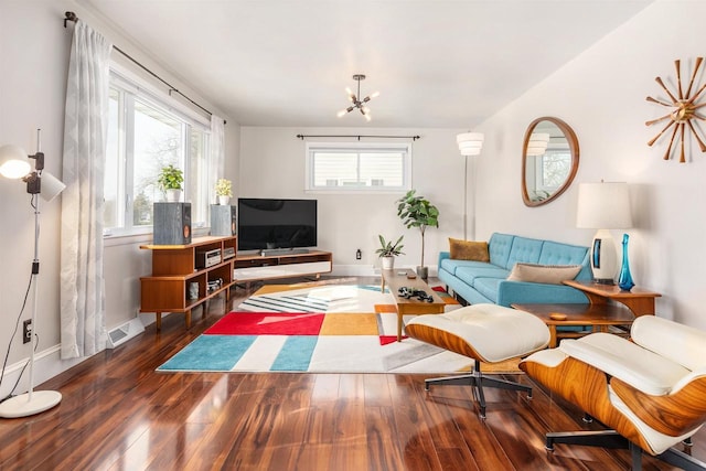 living room featuring visible vents, baseboards, an inviting chandelier, and wood finished floors