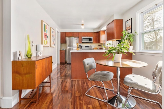 dining space featuring dark wood-style floors and baseboards