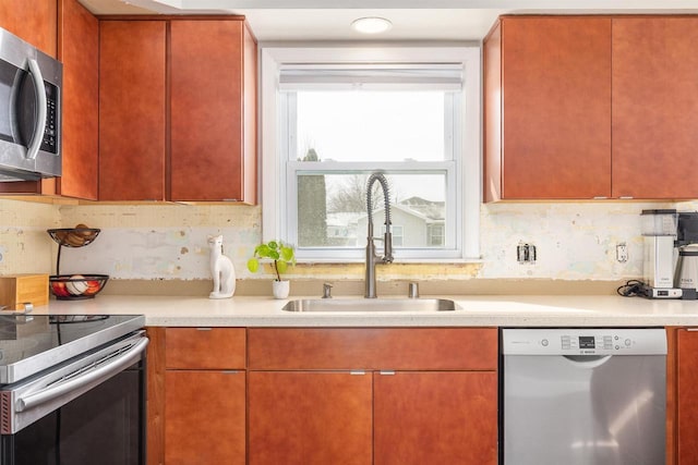 kitchen featuring light countertops, appliances with stainless steel finishes, and a sink