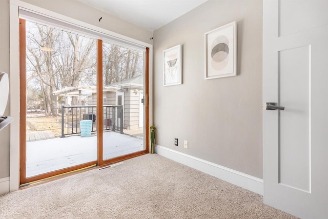 doorway with baseboards and carpet