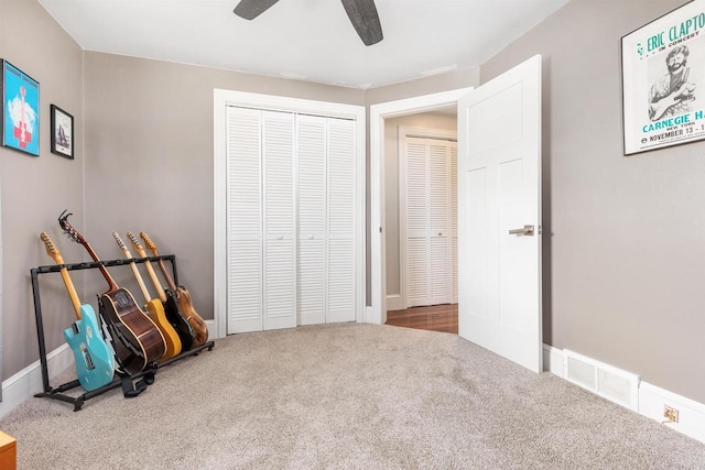 unfurnished room featuring carpet flooring, baseboards, visible vents, and ceiling fan