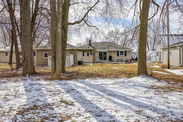 ranch-style house with central AC unit and a chimney