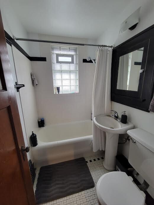 full bath with tile patterned floors, toilet, and shower / bath combination with curtain