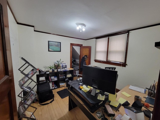 office area with light wood-type flooring and ornamental molding