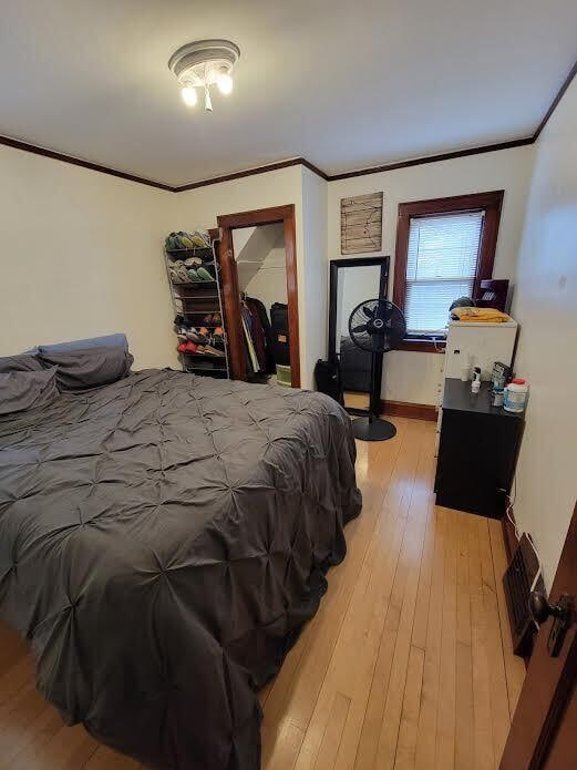 bedroom featuring crown molding, baseboards, and hardwood / wood-style floors