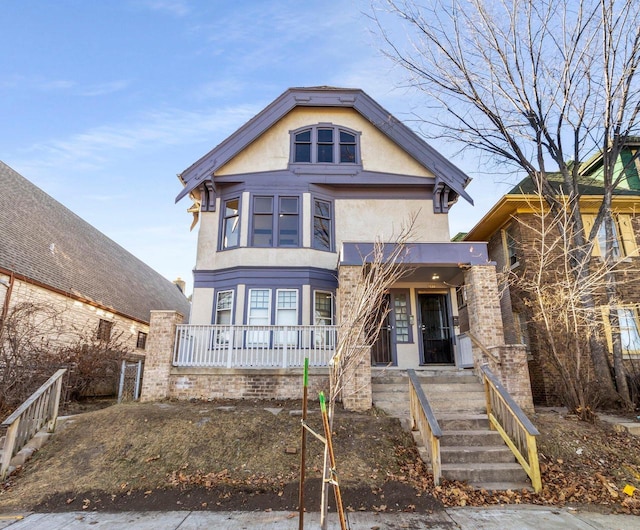 view of front facade with covered porch and stucco siding