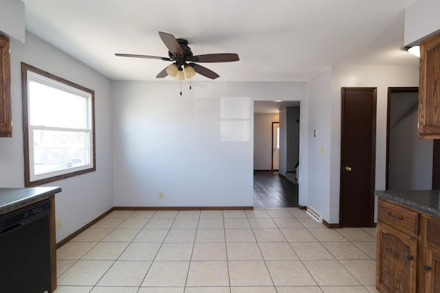 kitchen featuring dark countertops, baseboards, dishwasher, light tile patterned flooring, and a ceiling fan