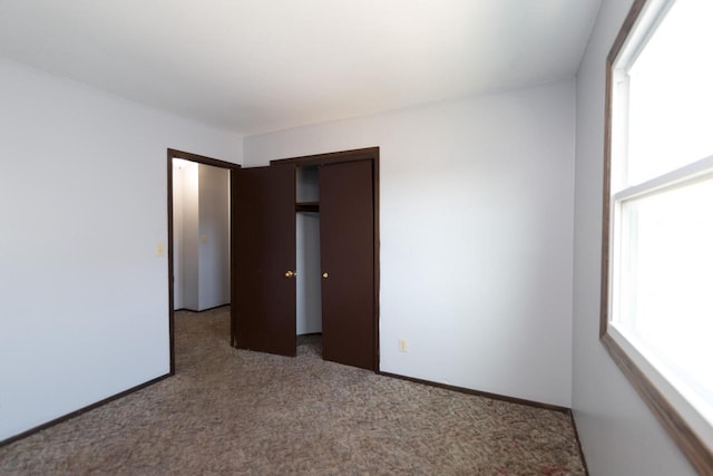 unfurnished bedroom featuring a closet, baseboards, and carpet floors