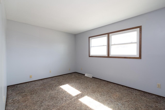 spare room with visible vents, baseboards, and carpet floors