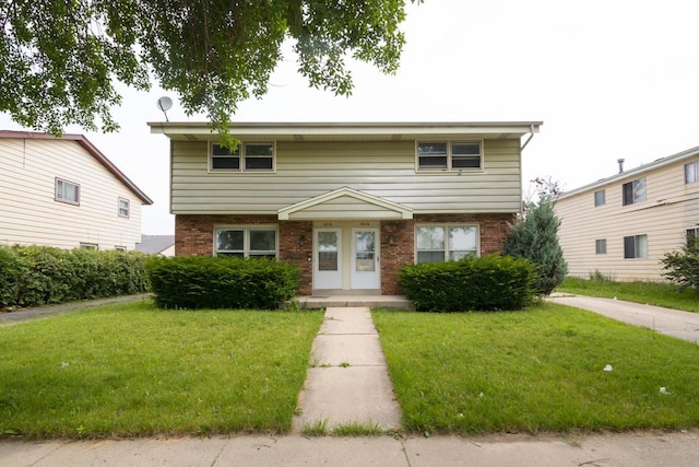 colonial-style house featuring brick siding and a front lawn