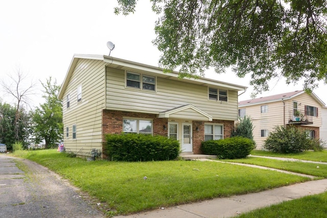 view of front of property featuring a front lawn and brick siding