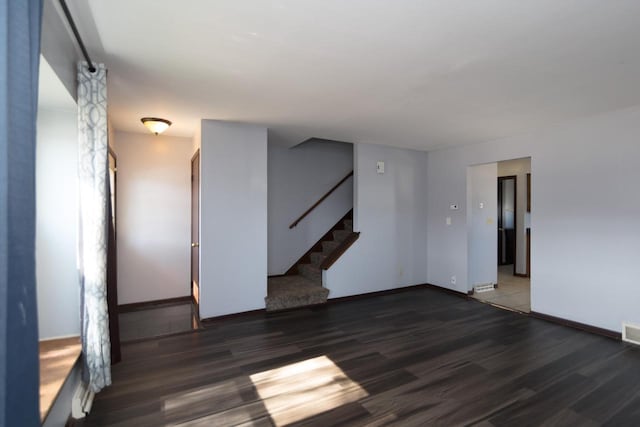 spare room with stairs, wood finished floors, and baseboards