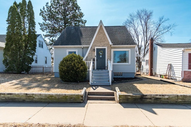 view of front of home featuring a fenced front yard and a shingled roof