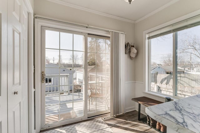 doorway to outside with baseboards, wood finished floors, and crown molding