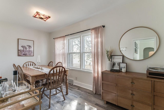 dining space with baseboards and light wood finished floors