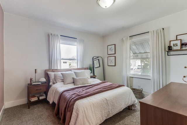 bedroom featuring baseboards, multiple windows, and carpet