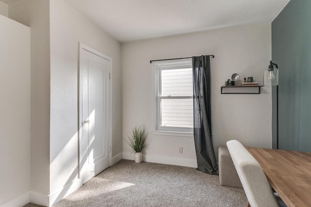 carpeted home office featuring baseboards