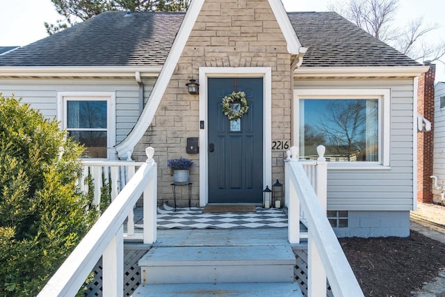 property entrance featuring roof with shingles