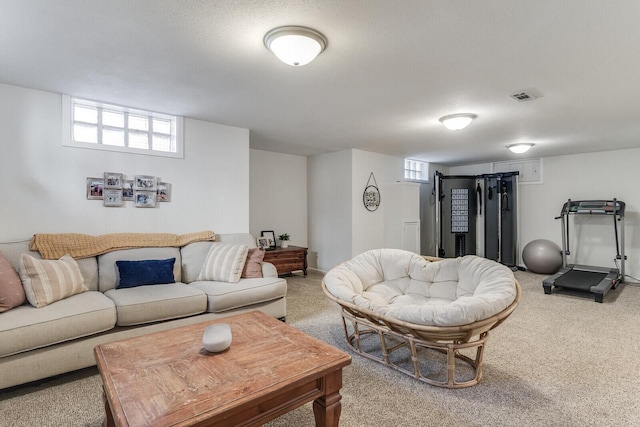 living area with visible vents and light carpet