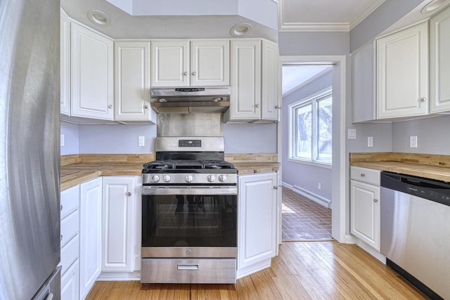 kitchen featuring ornamental molding, under cabinet range hood, white cabinetry, stainless steel appliances, and light wood-style floors