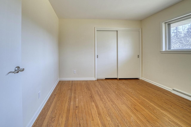 unfurnished bedroom featuring a closet, visible vents, light wood-style floors, and baseboards