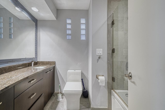 bathroom with tile patterned flooring, baseboards, washtub / shower combination, toilet, and vanity