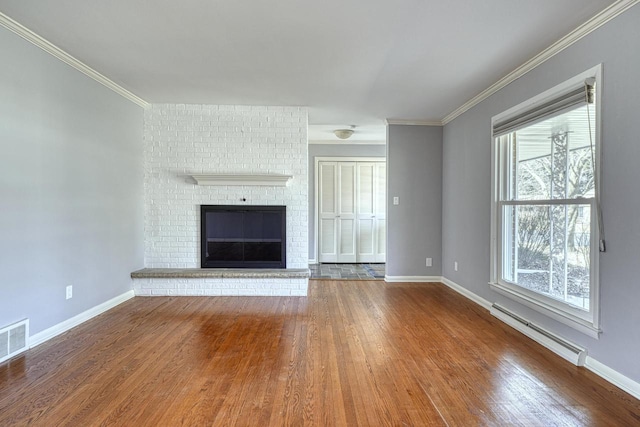 unfurnished living room featuring crown molding, wood finished floors, and baseboard heating