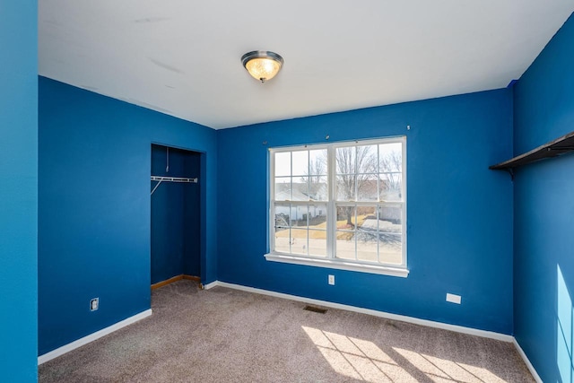 unfurnished bedroom featuring a closet, visible vents, carpet, and baseboards