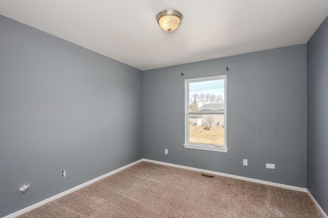 carpeted empty room with visible vents and baseboards