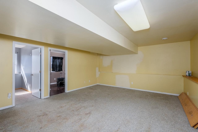 carpeted empty room featuring baseboards