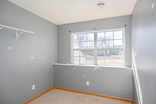 carpeted empty room featuring visible vents and baseboards