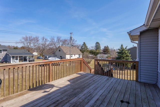 wooden terrace with a residential view and a lawn