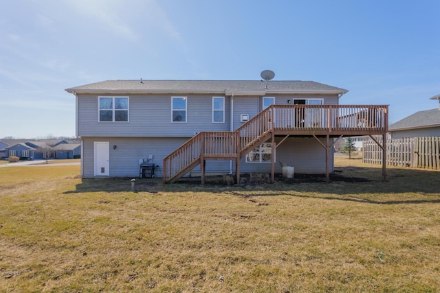 rear view of property featuring a lawn, a wooden deck, stairs, and fence