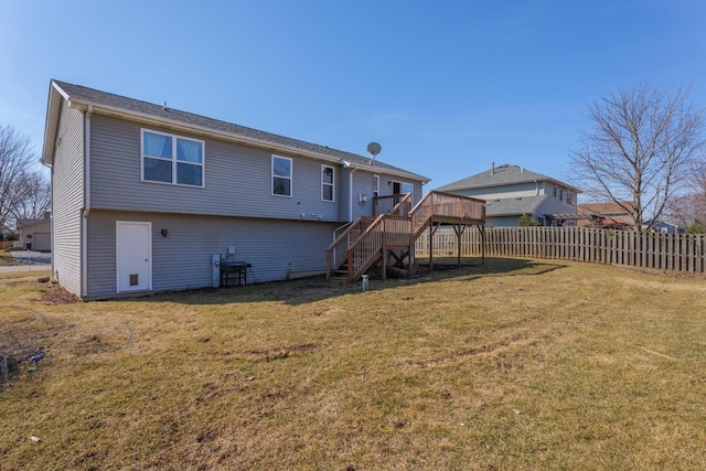 back of house featuring a lawn, stairs, and fence