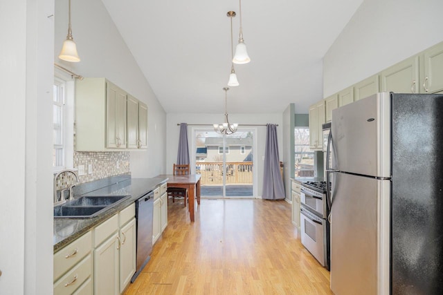 kitchen featuring a sink, stainless steel appliances, tasteful backsplash, light wood-type flooring, and a chandelier