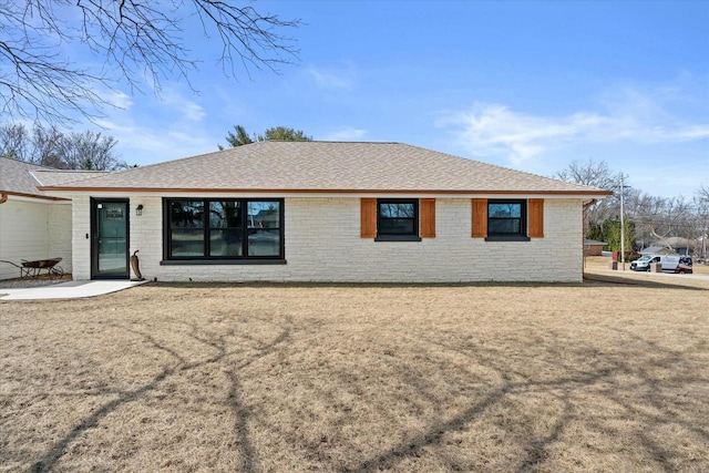 view of front of property featuring brick siding and a shingled roof