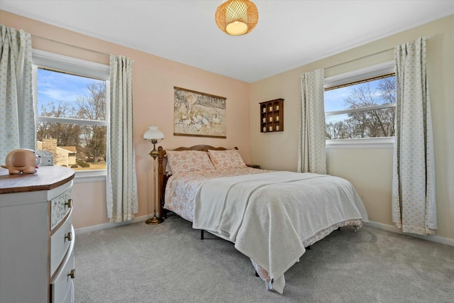 bedroom with light colored carpet and baseboards