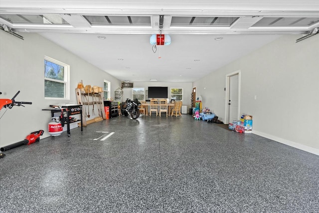 garage featuring a garage door opener and baseboards